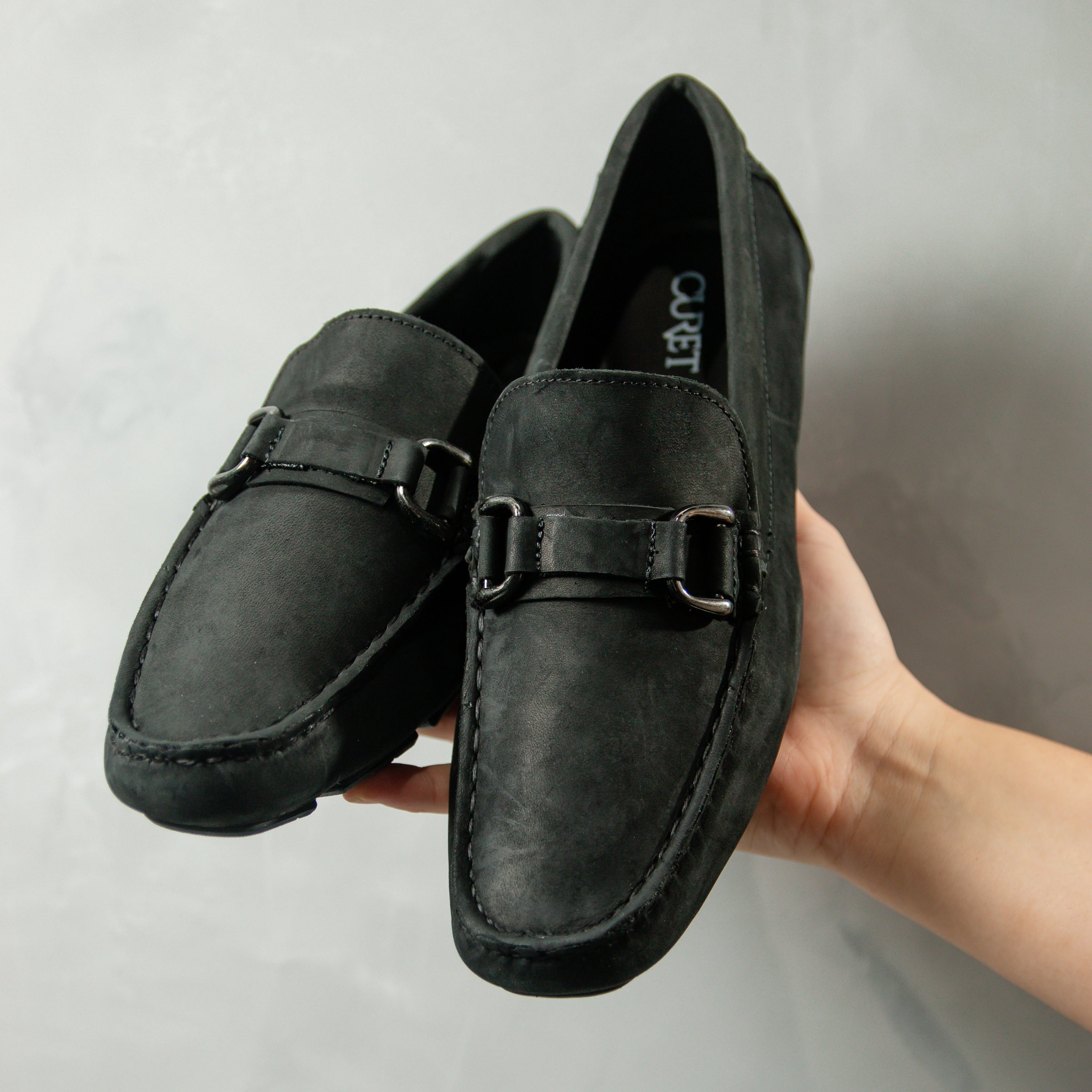 Mocasín Drive en elegante negro, confeccionado en piel nobuck para brindar estilo y comodidad. Un calzado clásico y sofisticado que realza tu imagen con su diseño atemporal.
